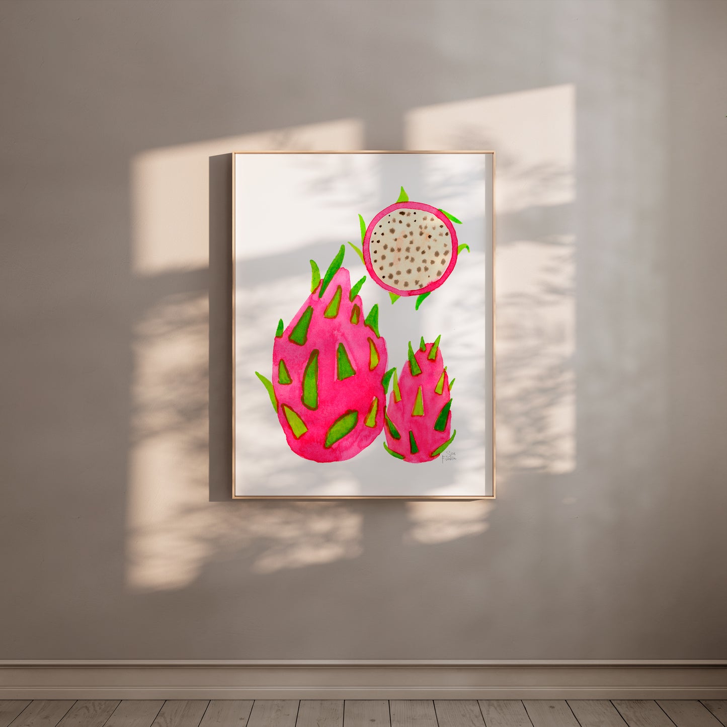 a framed artwork of three dragon fruits hanging on a wall.