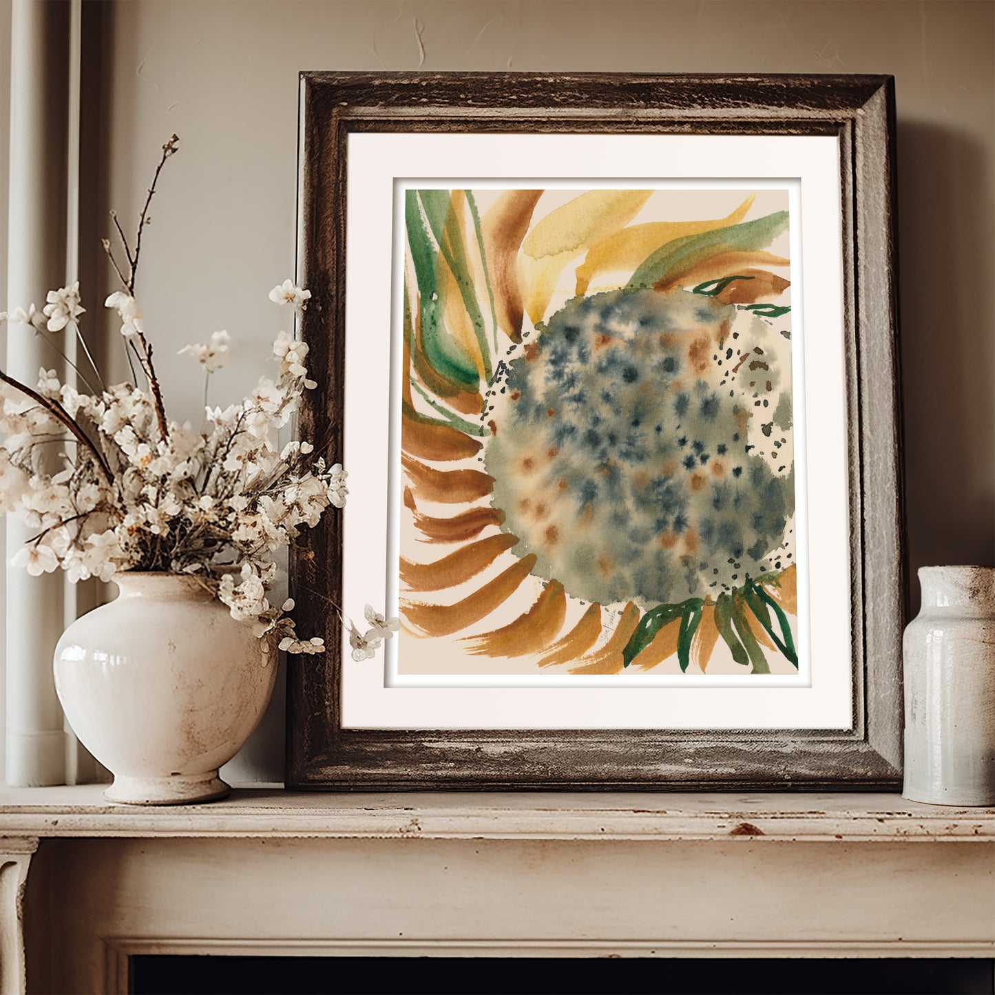 a framed watercolor painting of a sunflower, placed on a shelf next to a vase of white flowers.