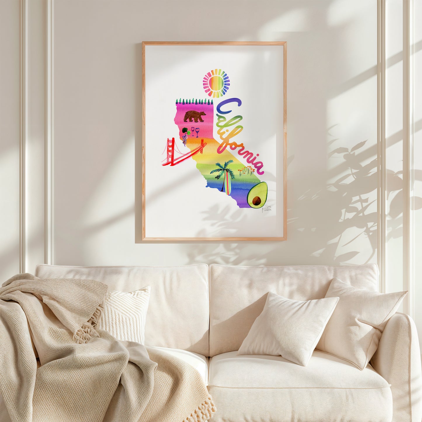 a living room with a white couch and a poster