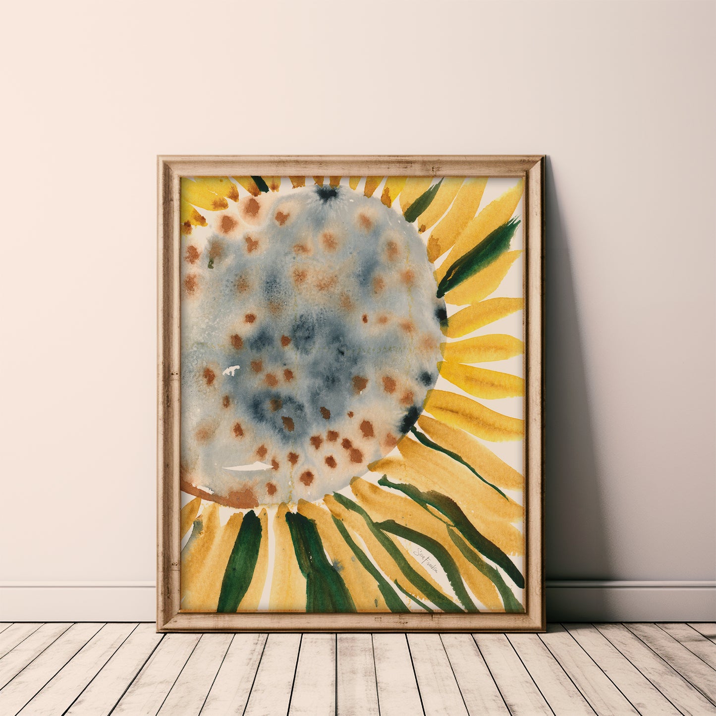 a large, vibrant watercolor painting of a sunflower, with a blue and yellow color scheme. The painting is framed and displayed on a wooden floor against a white wall.
