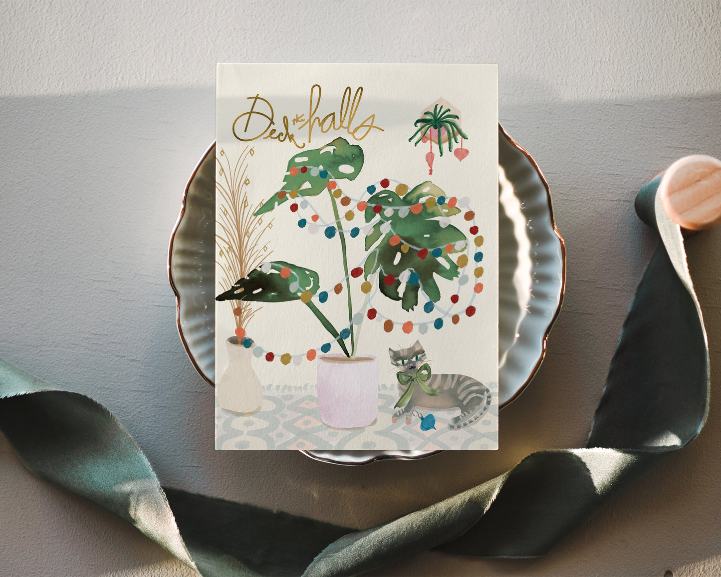 a greeting card with a cat sitting on a plate
