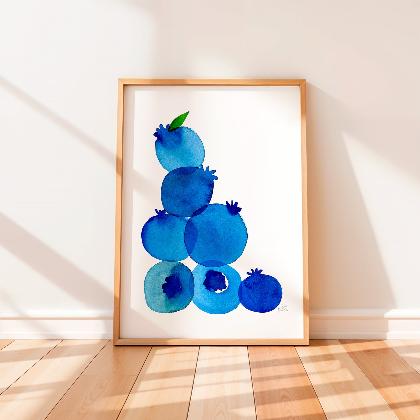 a framed watercolor painting of blueberries on a white background.