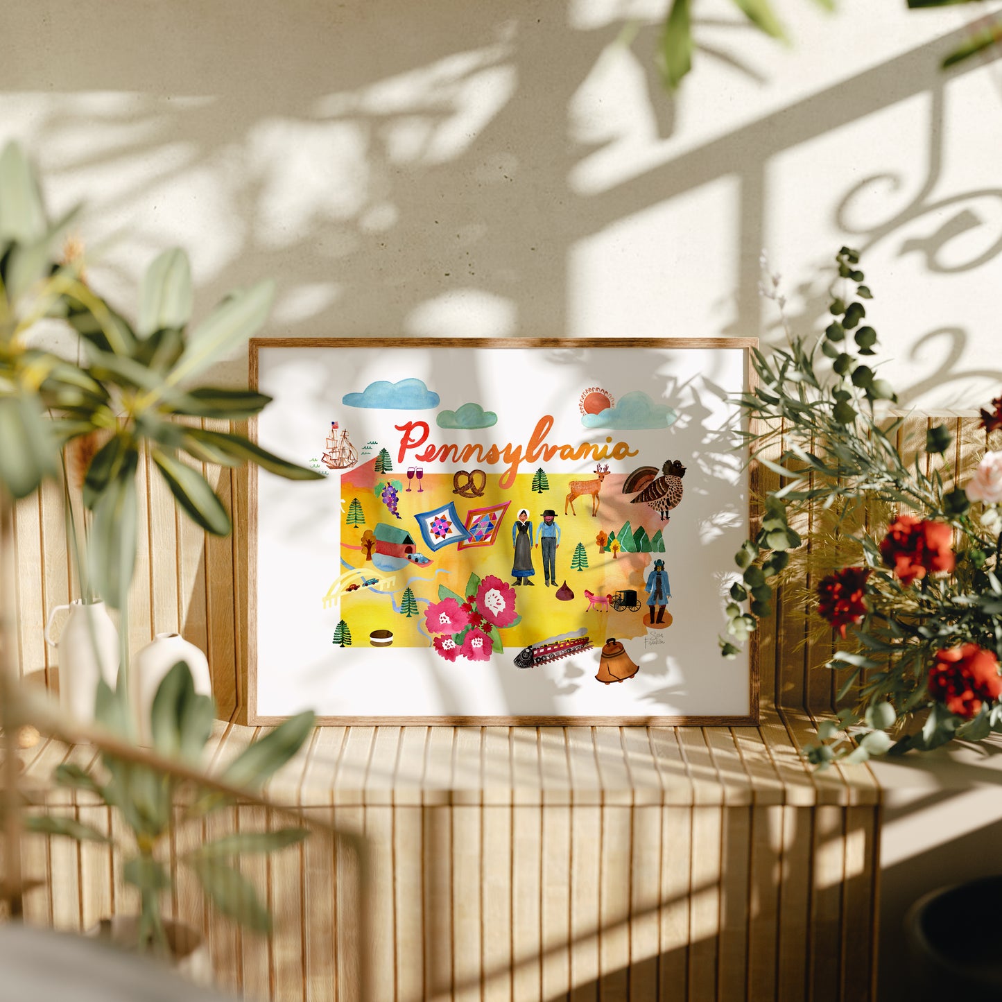 a picture of a picture hanging on a wall next to a potted plant