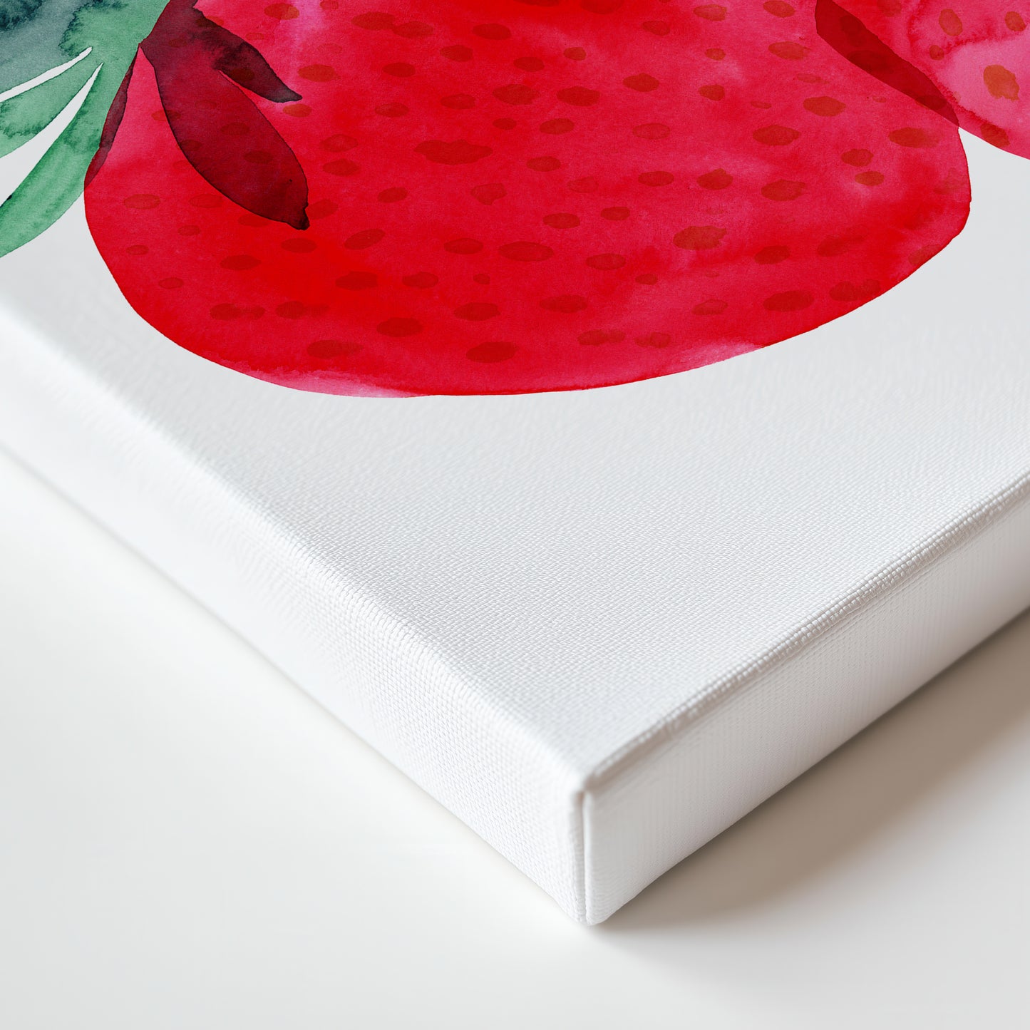 a close-up view of a white canvas with a vibrant red watercolor painting of a strawberry on it.