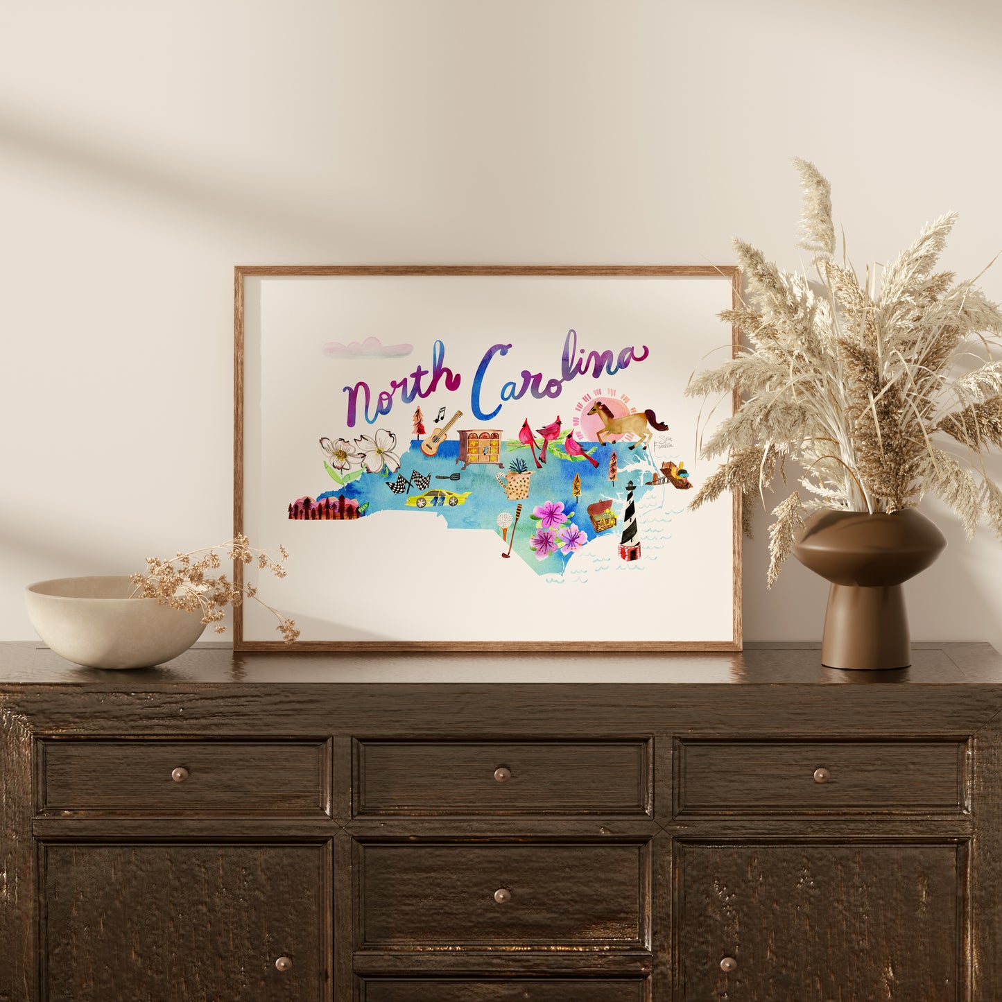 a picture of north carolina on a wall above a dresser