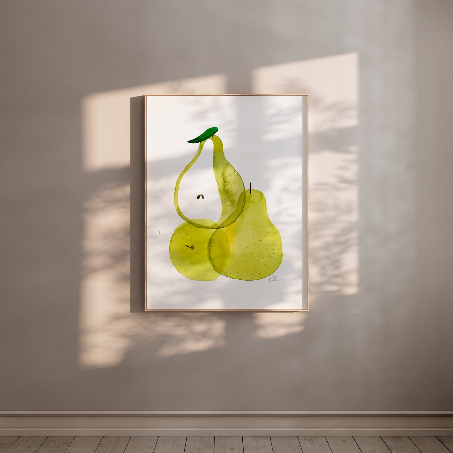 a framed artwork of three green pears hanging on a wall.