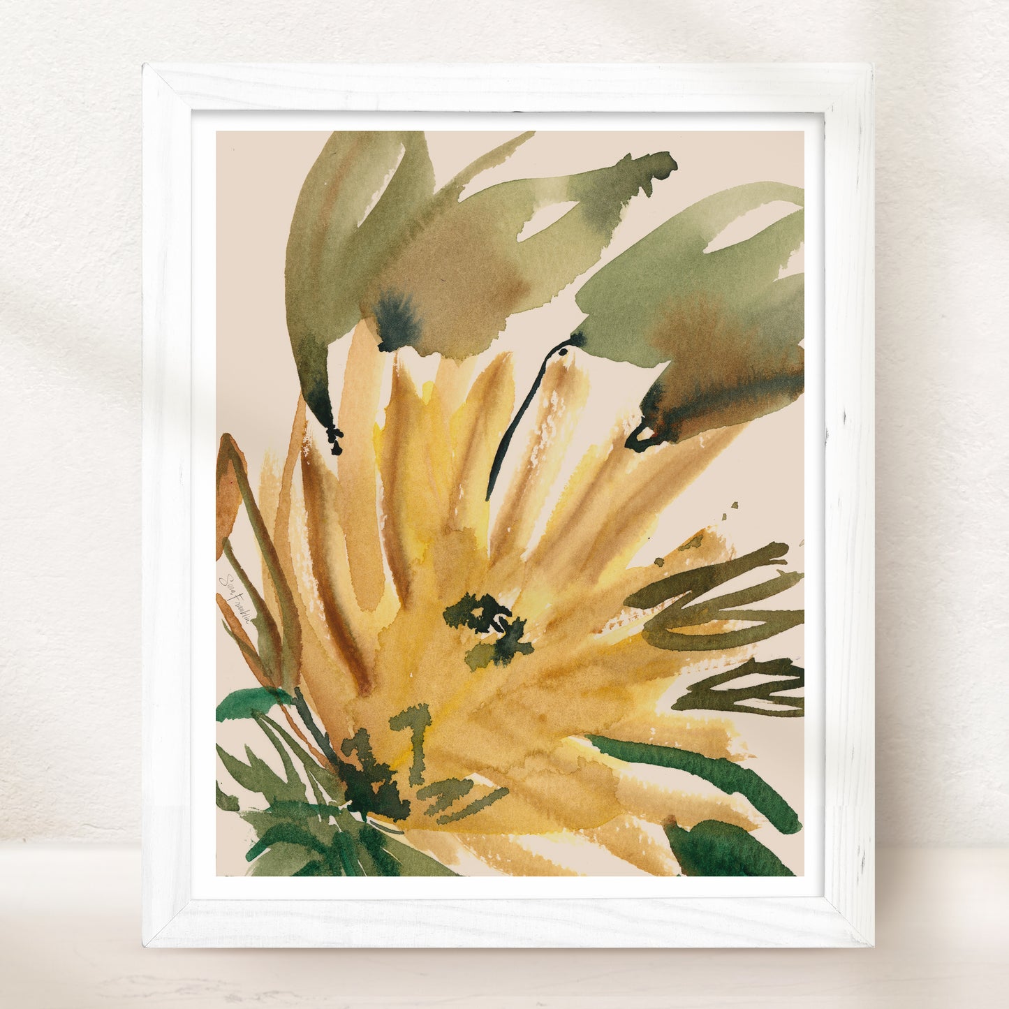 The image is a framed watercolor painting depicting a vibrant yellow flower with green leaves.