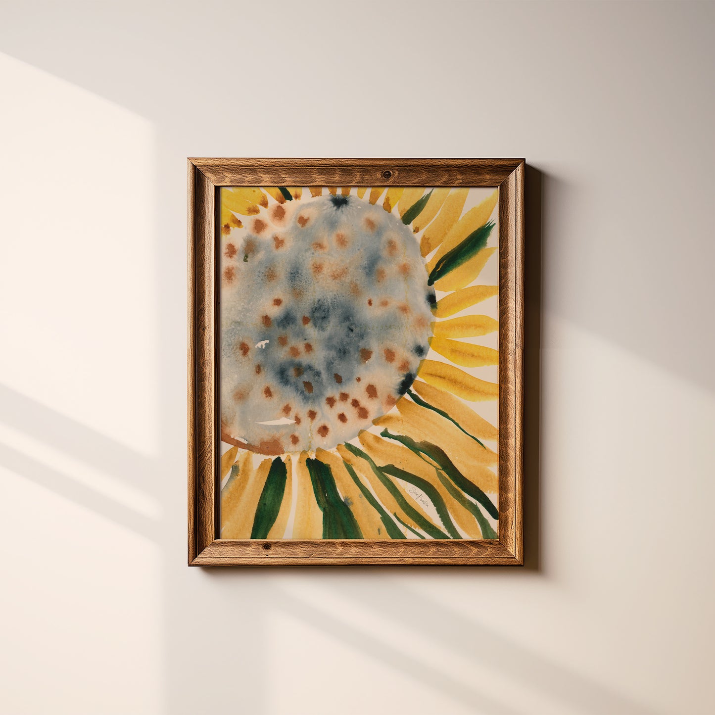 a framed watercolor painting of a sunflower on a white wall.