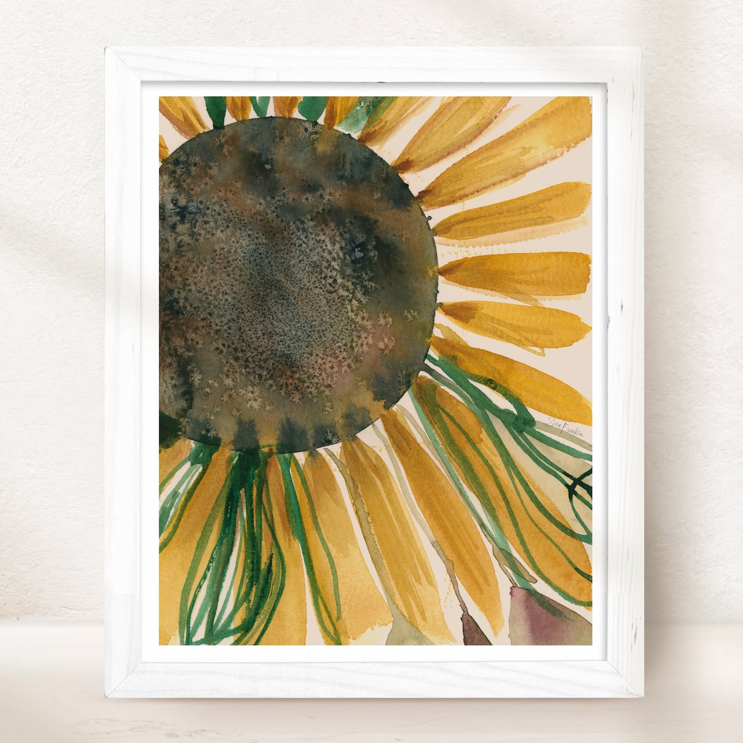 The image is a framed watercolor painting depicting a vibrant sunflower with yellow petals and green stems.