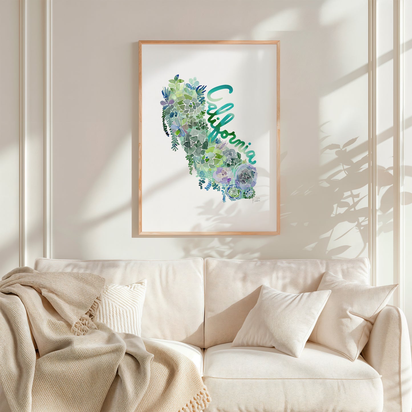a living room with a white couch and a picture hanging on the wall