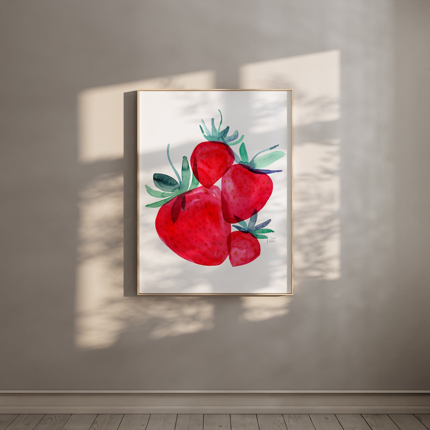 a framed watercolor painting of red strawberries hanging on a wall.