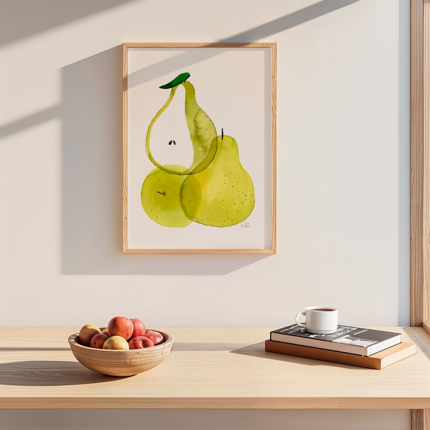a wooden table with a bowl of fruit, a cup of coffee, and a stack of books. Above the table, there is a framed painting of two green pears.