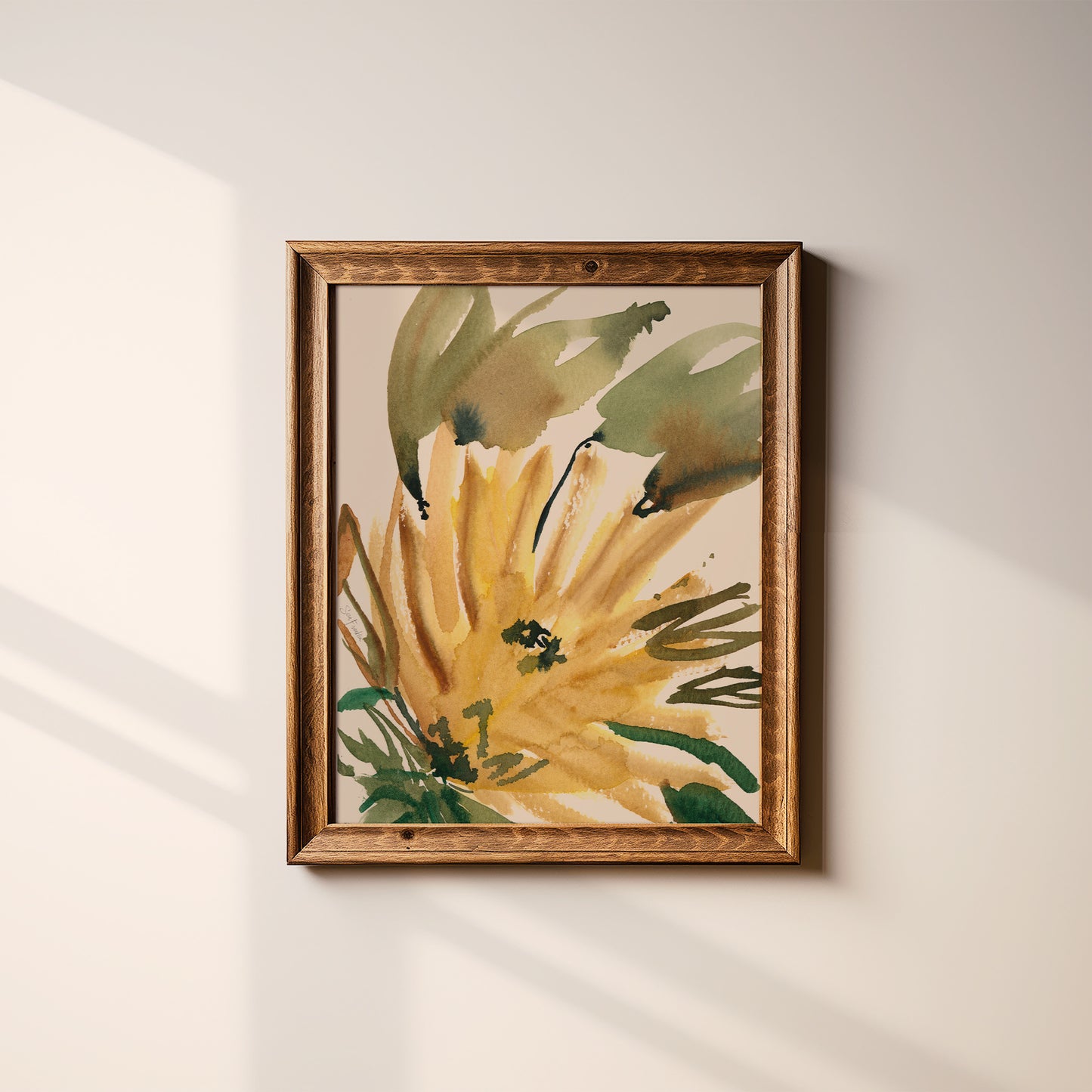 a framed painting of a yellow flower with green leaves, hanging on a white wall.