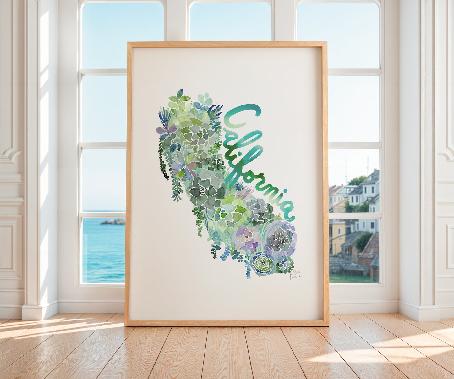 a picture frame sitting on a wooden floor in front of a window