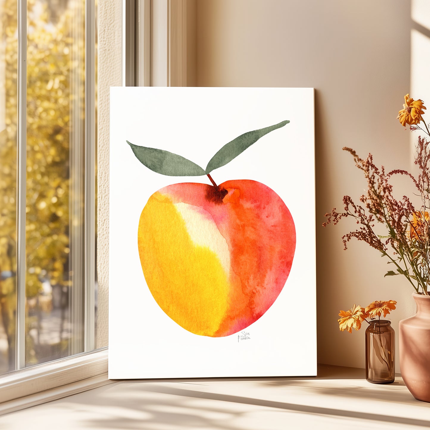 a framed watercolor painting of a peach with a green leaf, placed on a windowsill next to a vase of flowers.