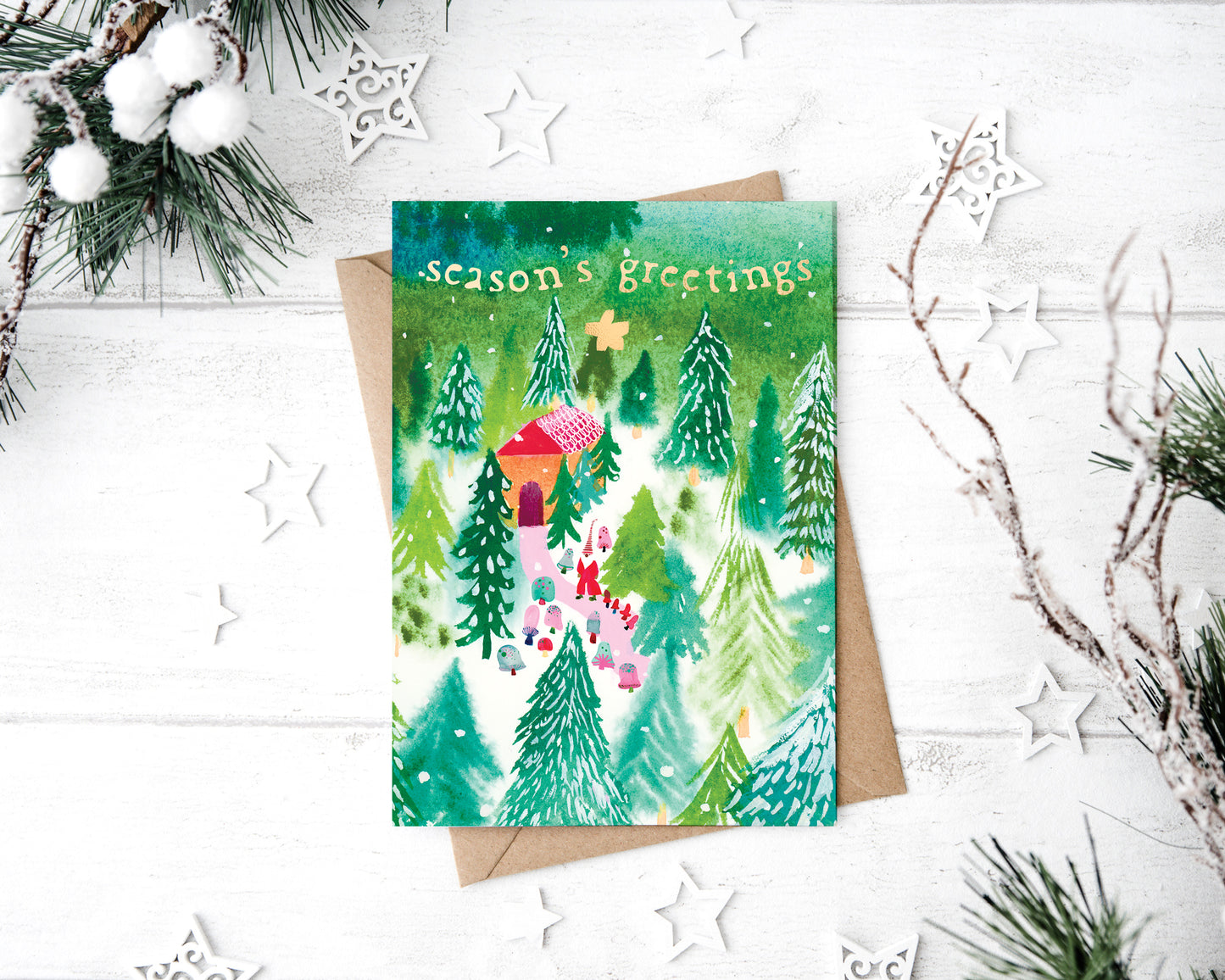 a christmas card with a picture of a house in the woods