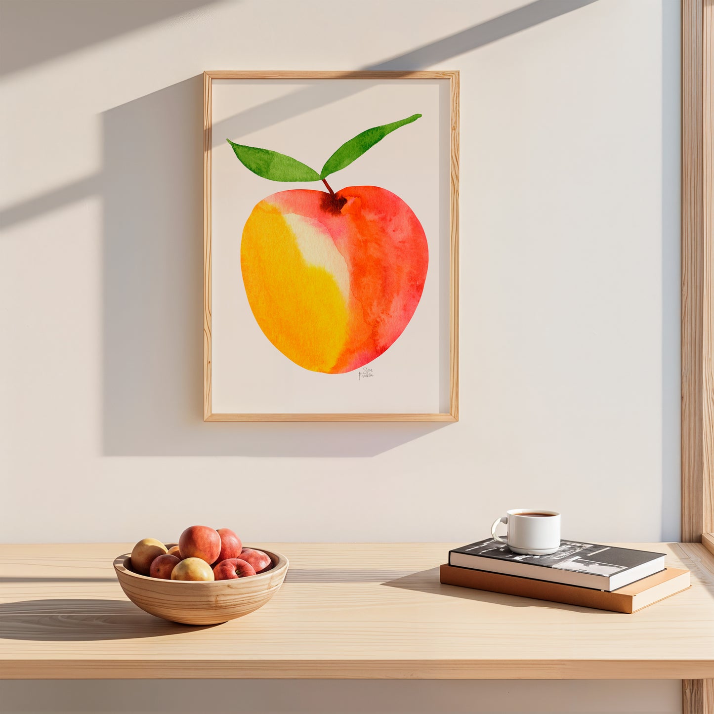 a wooden table with a bowl of apples, a cup of coffee, and a book, all set against a white wall with a framed painting of an apple hanging above it.
