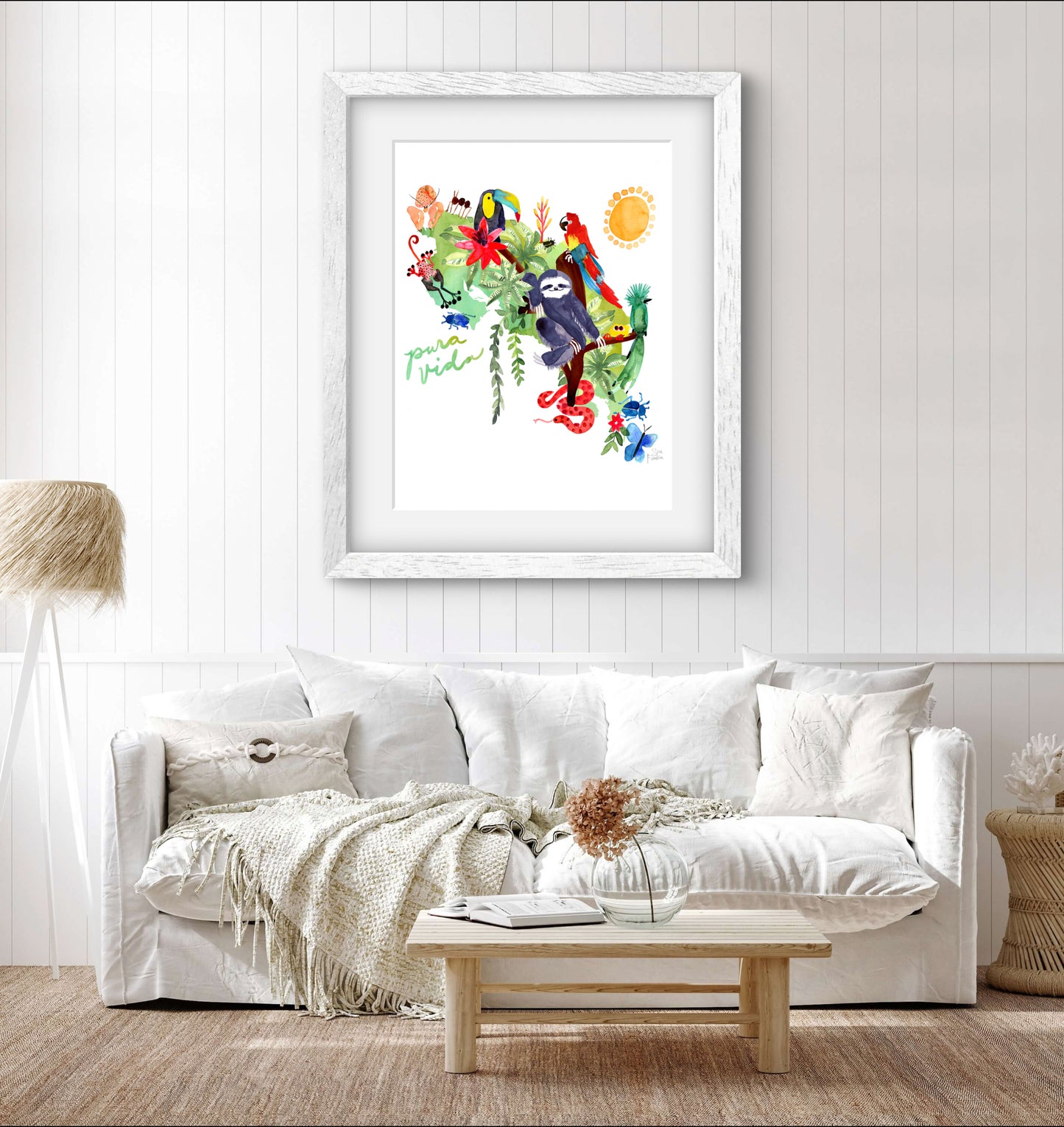 a living room with a white couch and a painting on the wall