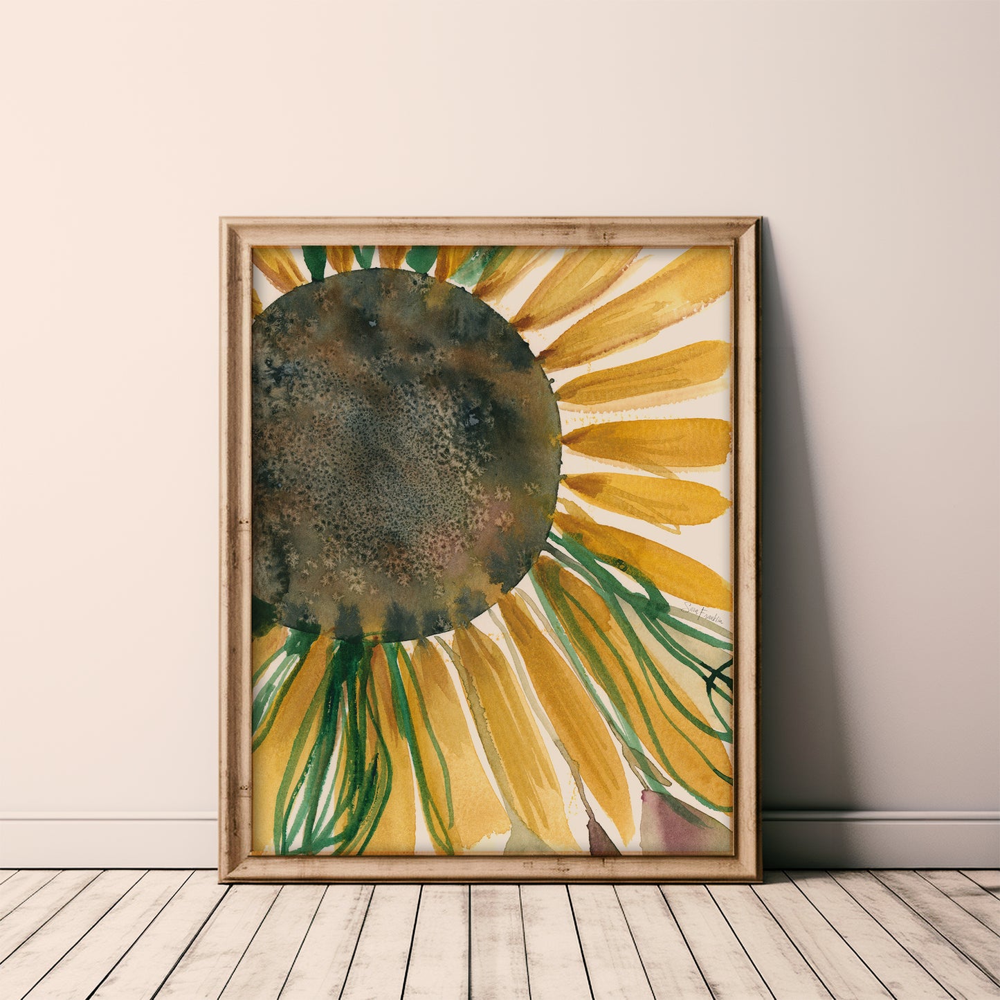 a framed painting of a sunflower, with vibrant yellow petals and green stems, displayed on a wooden floor against a white wall.