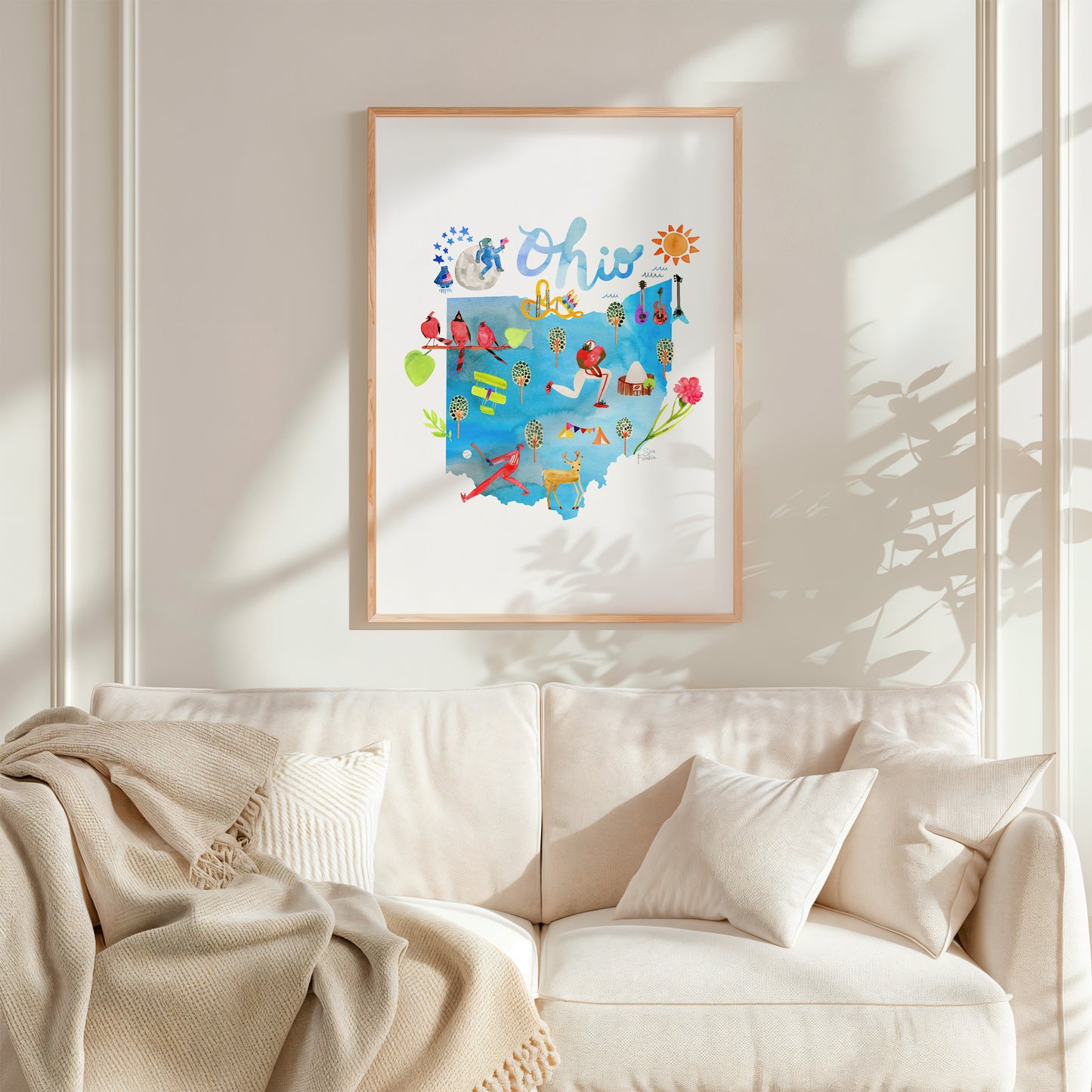 a living room with a white couch and a painting on the wall