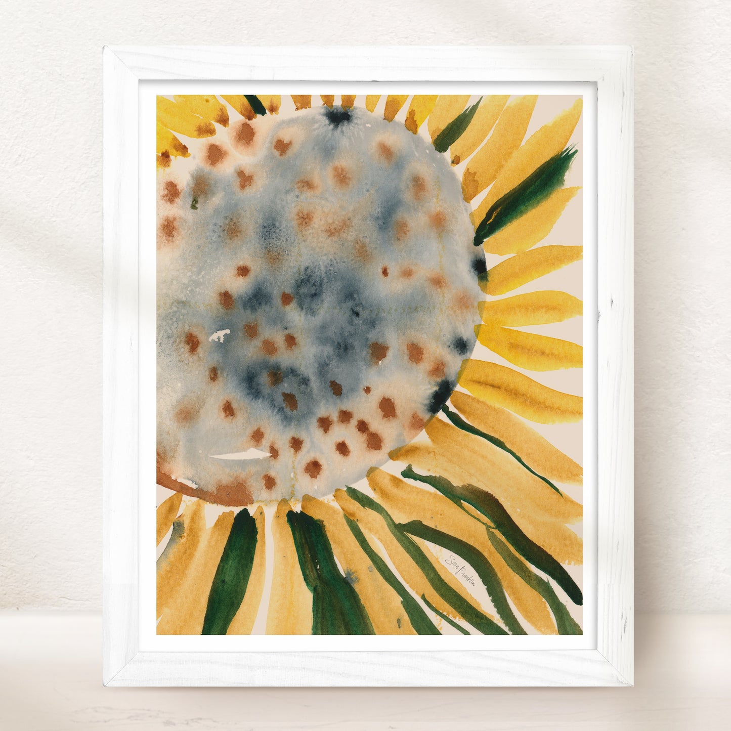 The image is a framed watercolor painting depicting a vibrant sunflower with yellow petals and green leaves.