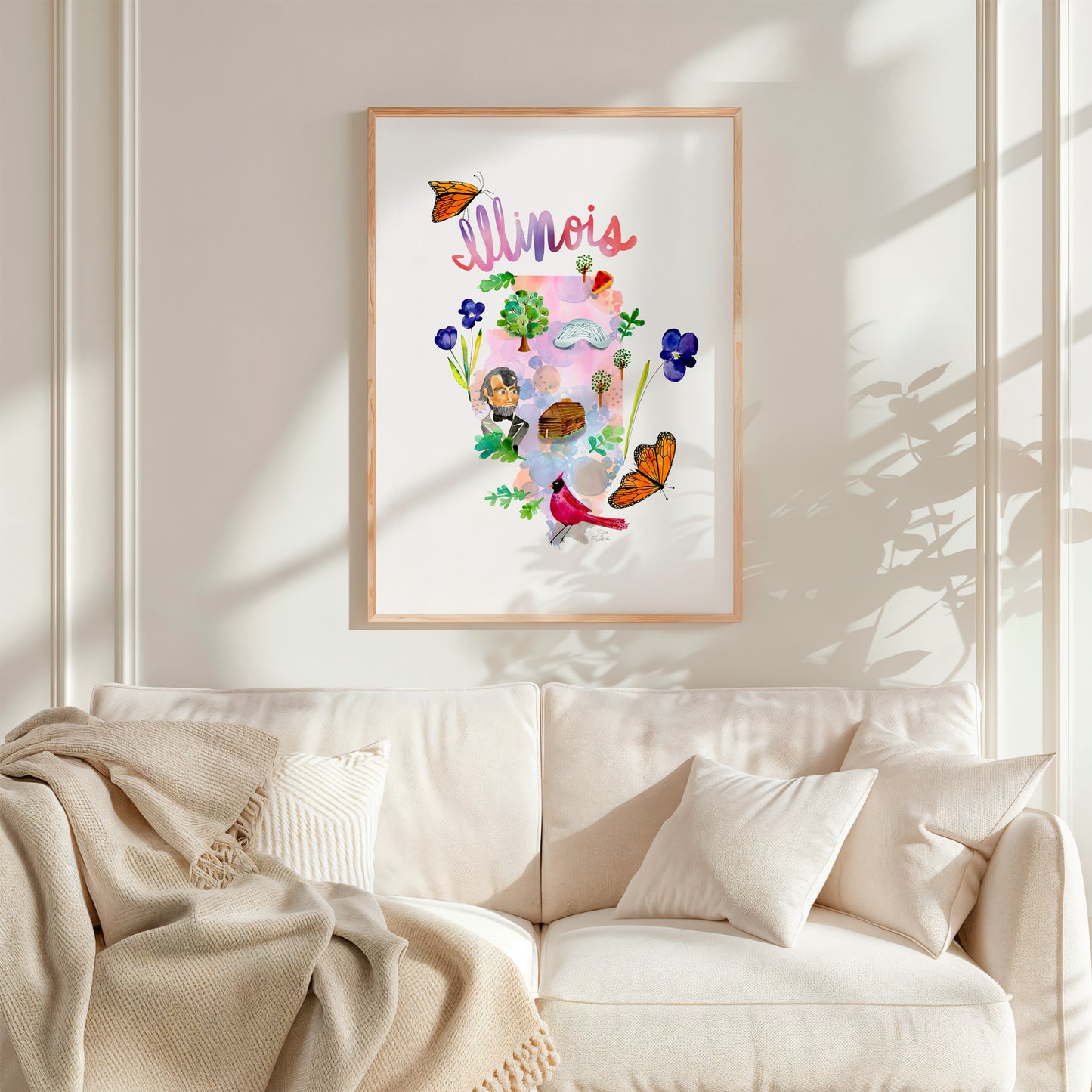 a living room with a white couch and a painting on the wall