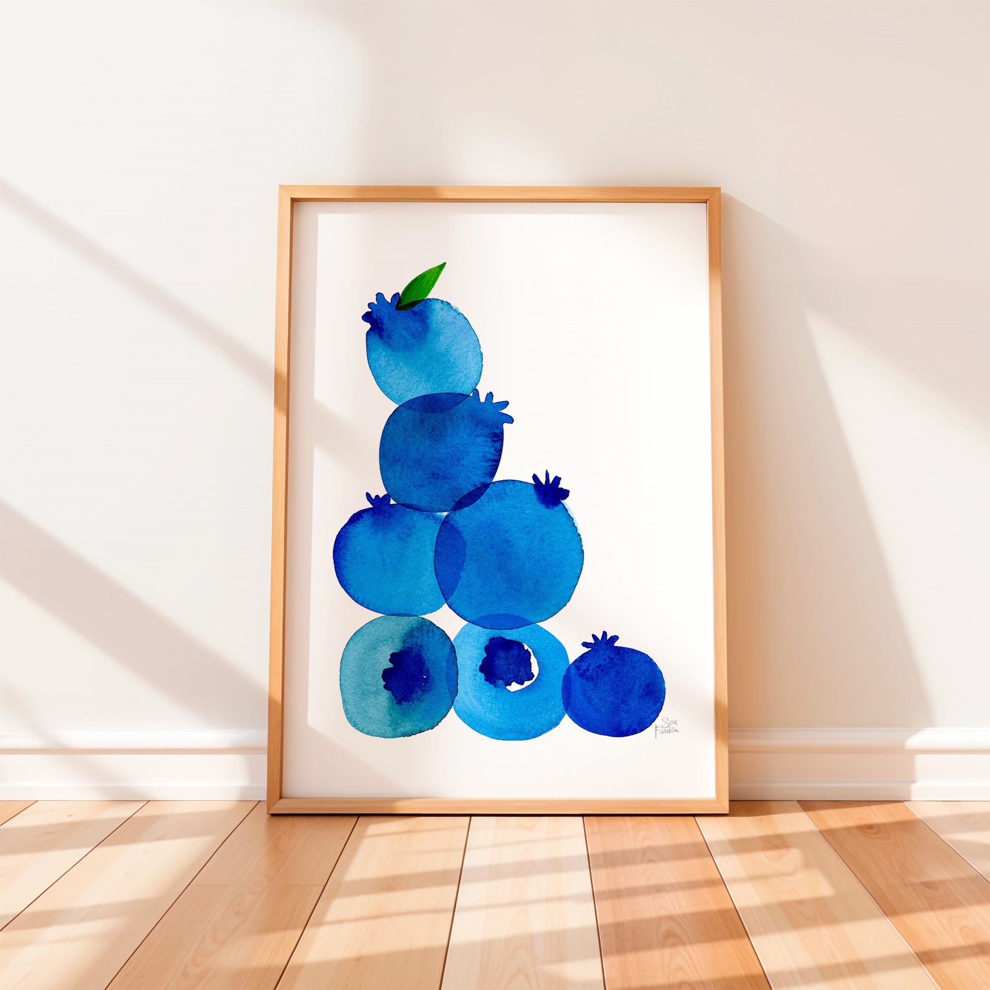 a framed watercolor painting of blueberries on a white background.