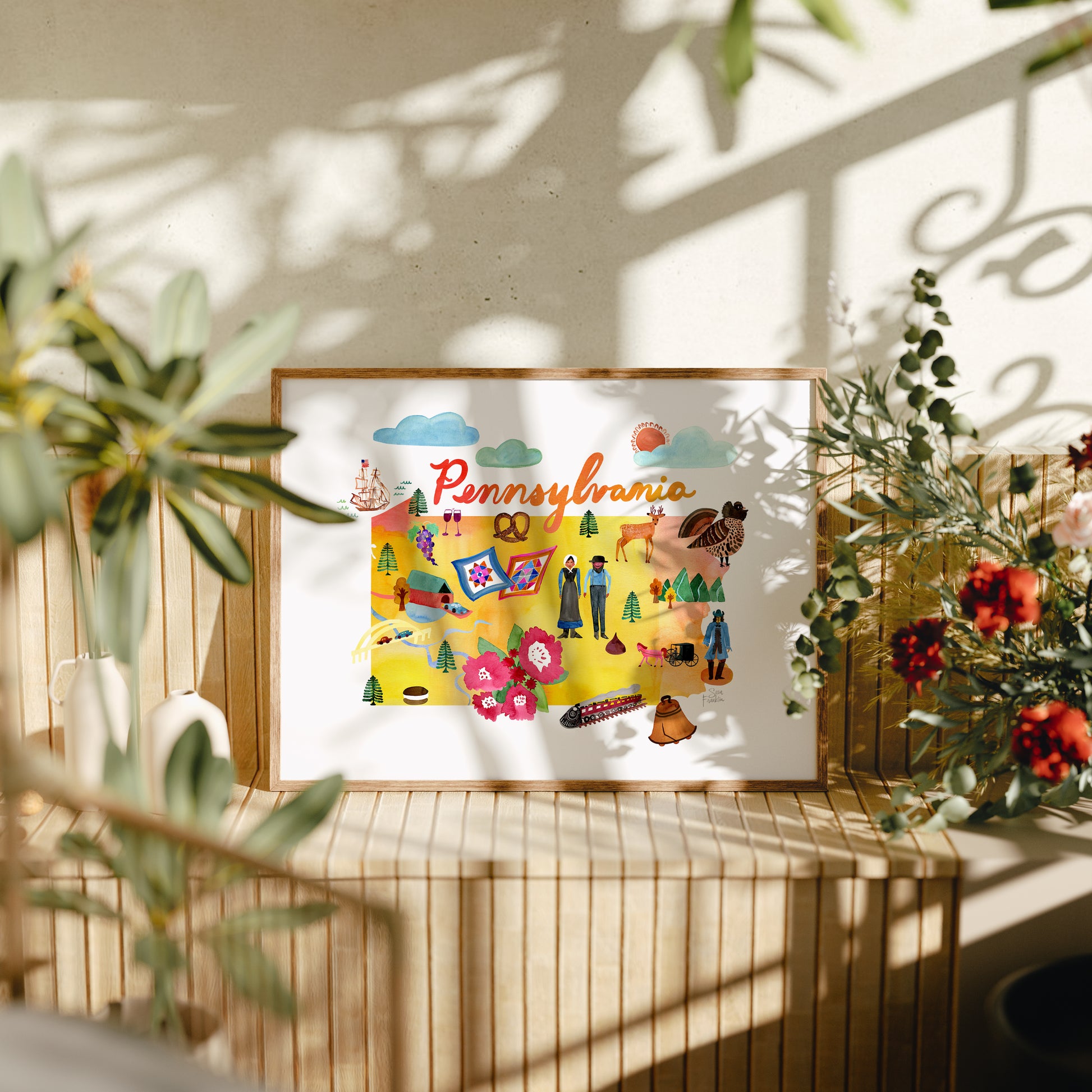 a picture of a picture hanging on a wall next to a potted plant