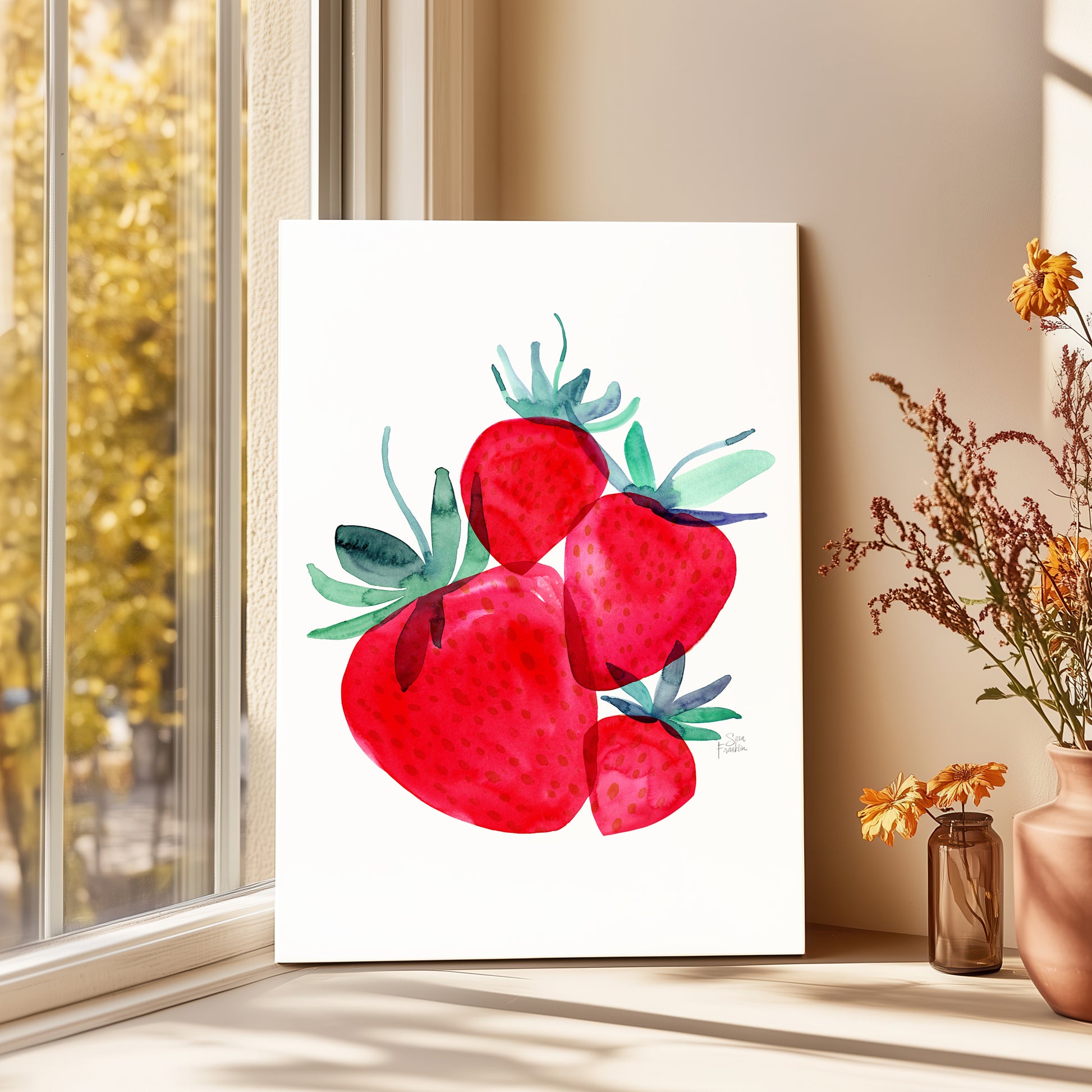 a white canvas with a vibrant watercolor painting of red strawberries, placed on a windowsill next to a vase of flowers.