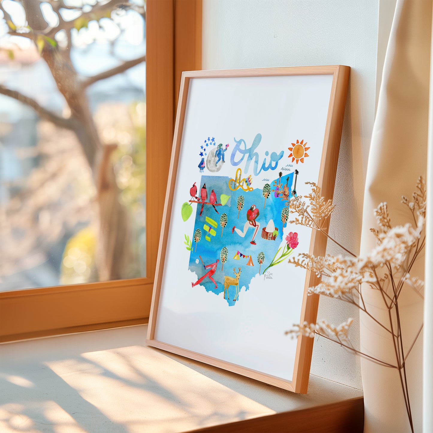 a picture frame sitting on a window sill next to a window