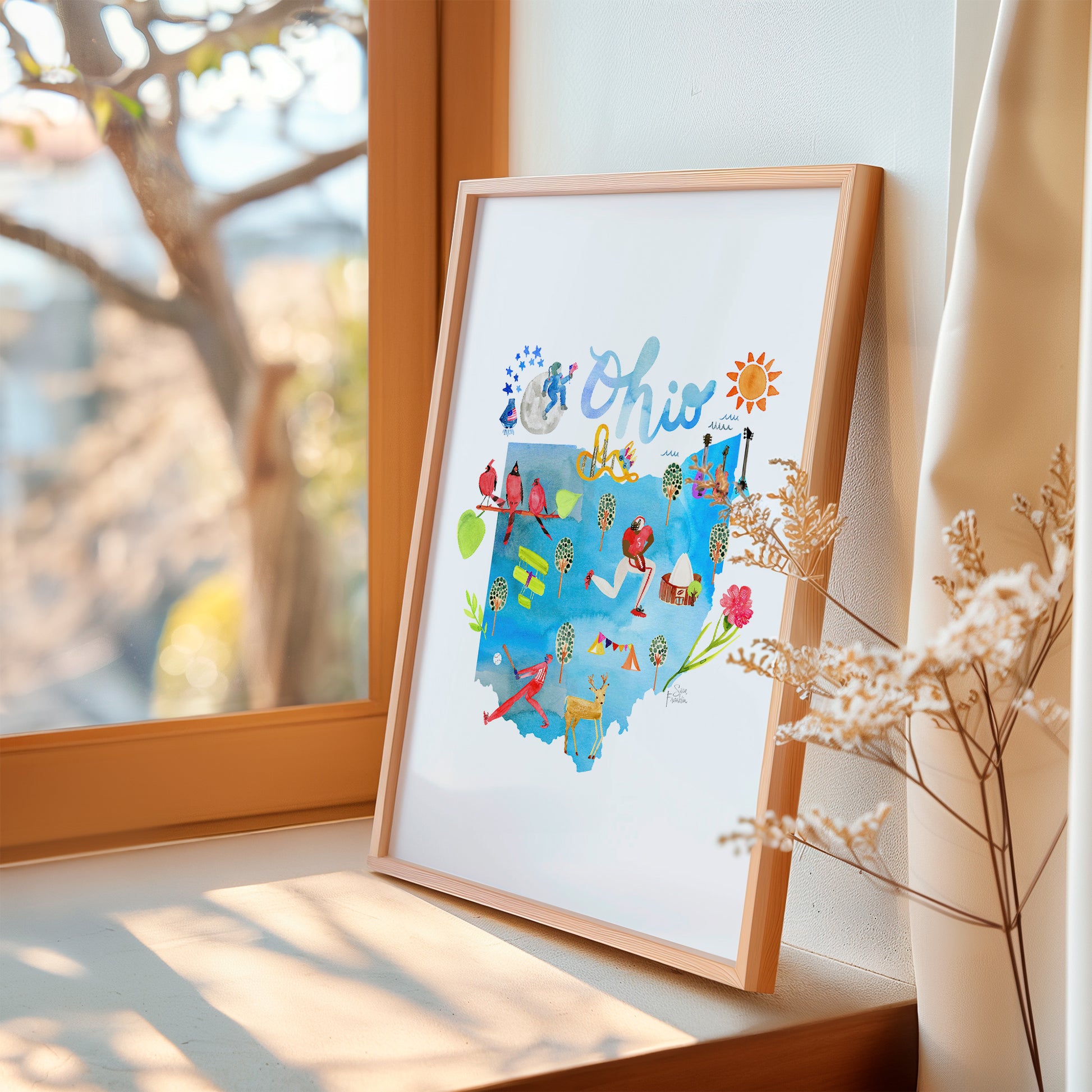 a picture frame sitting on a window sill next to a window