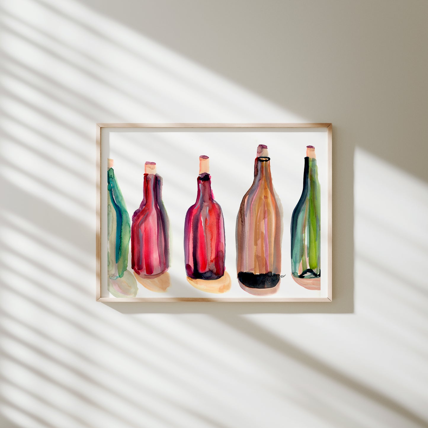 a collection of colorful bottles, including red, green, and yellow bottles, arranged in a row on a white wall.