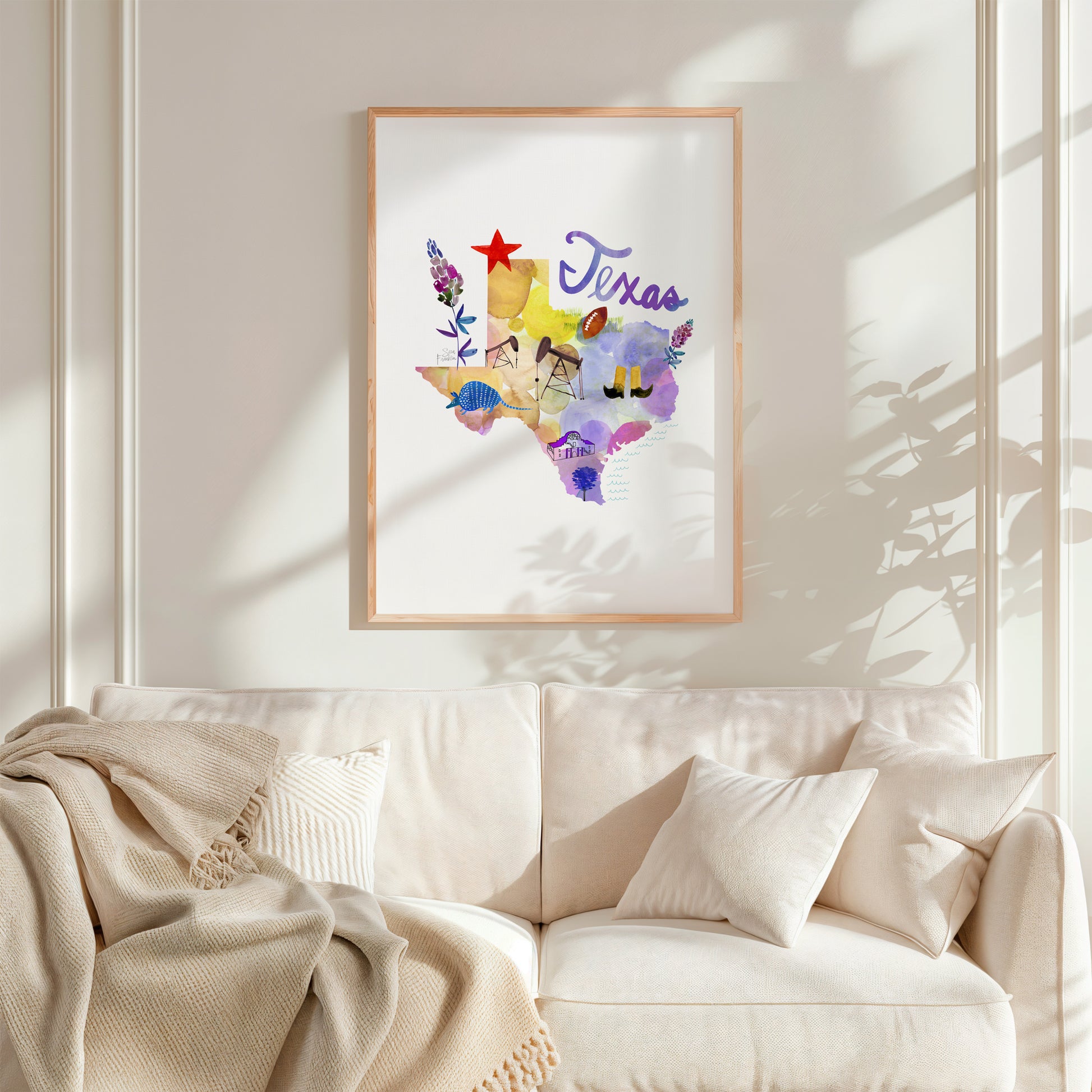 a living room with a white couch and a painting on the wall