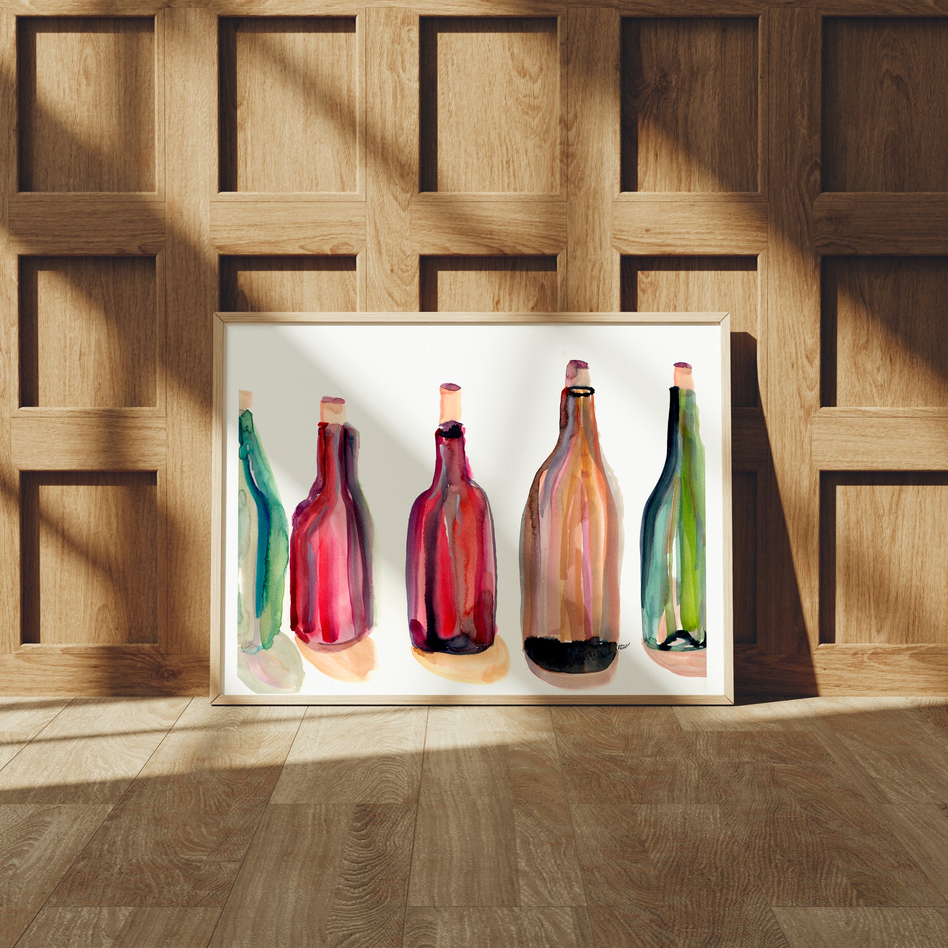 A framed collage of five colorful bottles of different shapes and sizes, displayed against a wooden paneled wall.