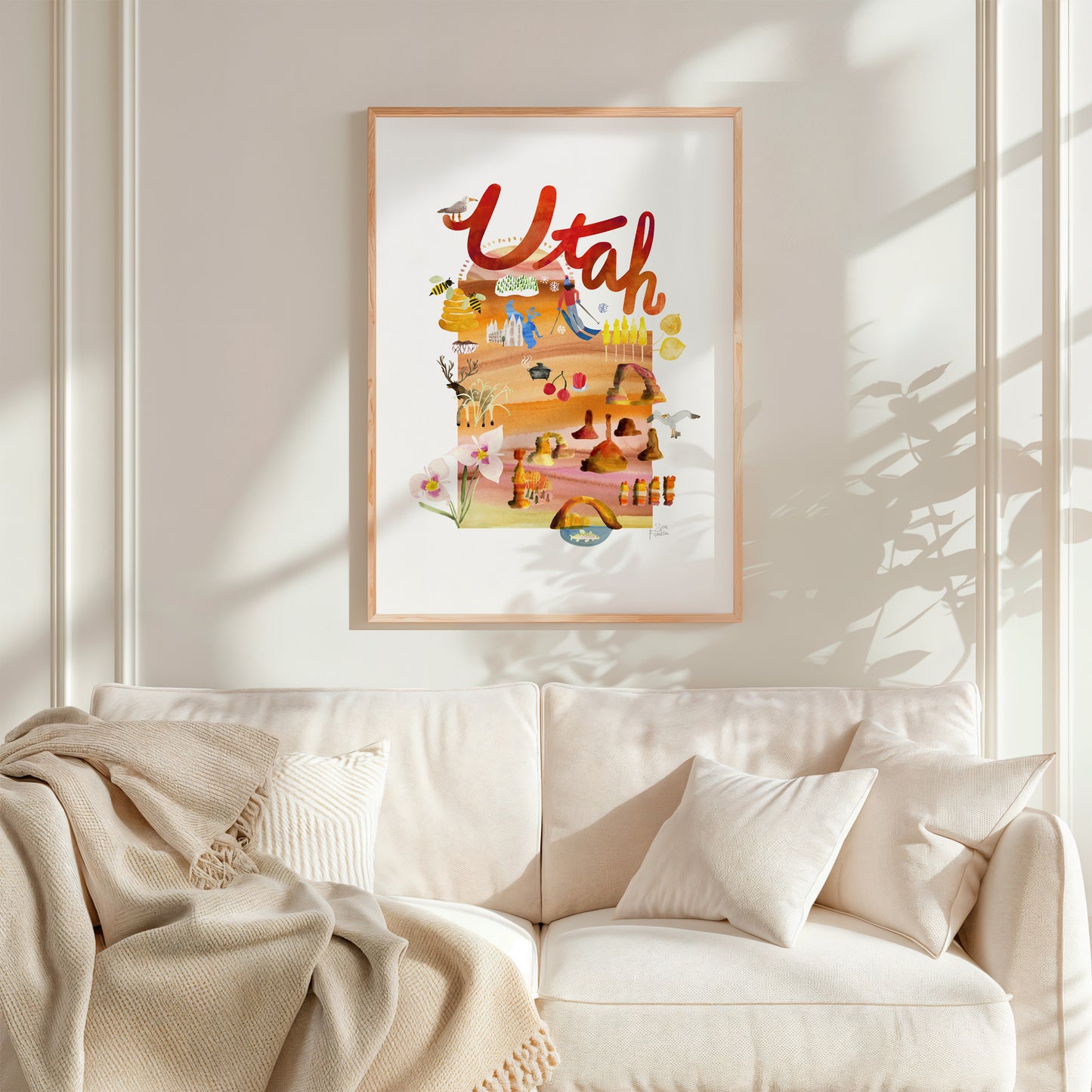 a living room with a white couch and a picture hanging on the wall
