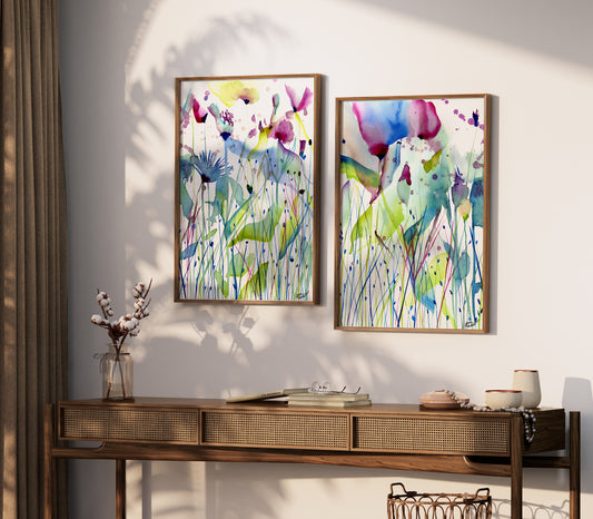 two paintings hang on a wall above a table