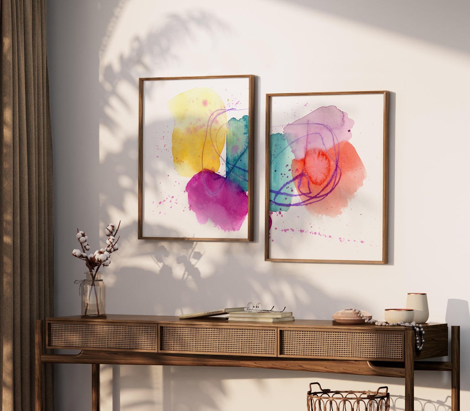 two paintings hang on a wall next to a table