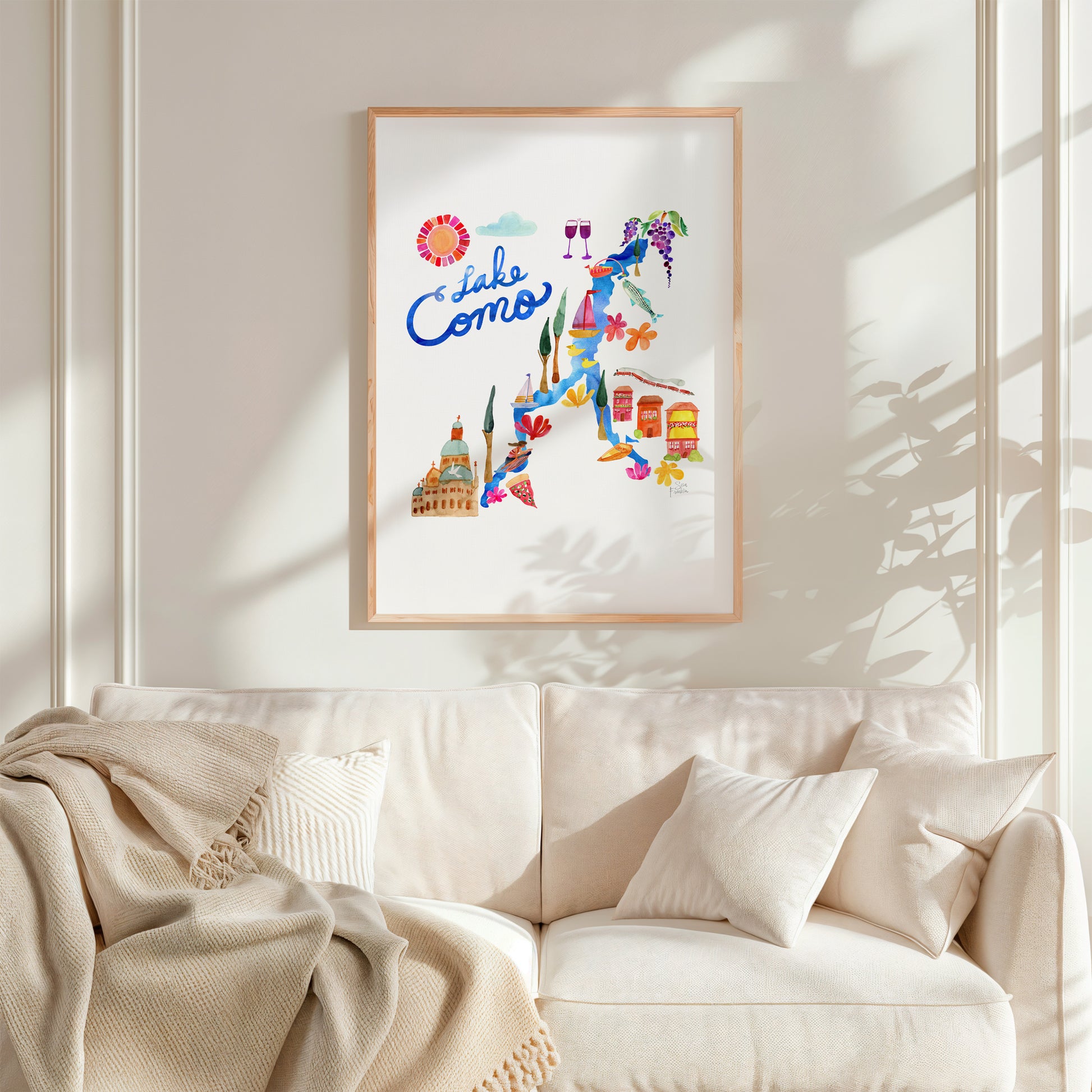 a living room with a white couch and a poster on the wall