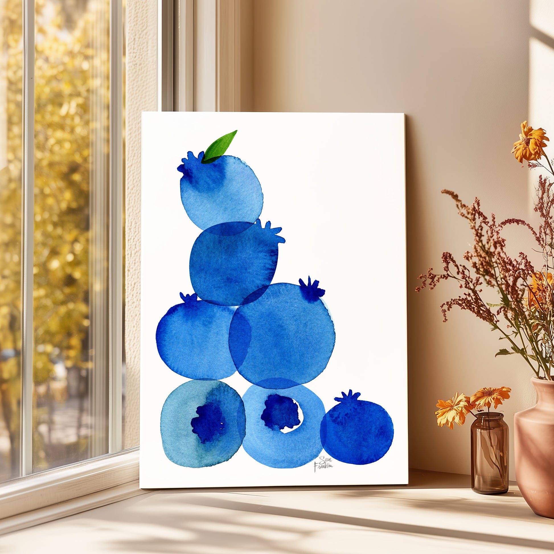 a painting of blueberries on a white background, placed on a windowsill next to a vase with flowers.