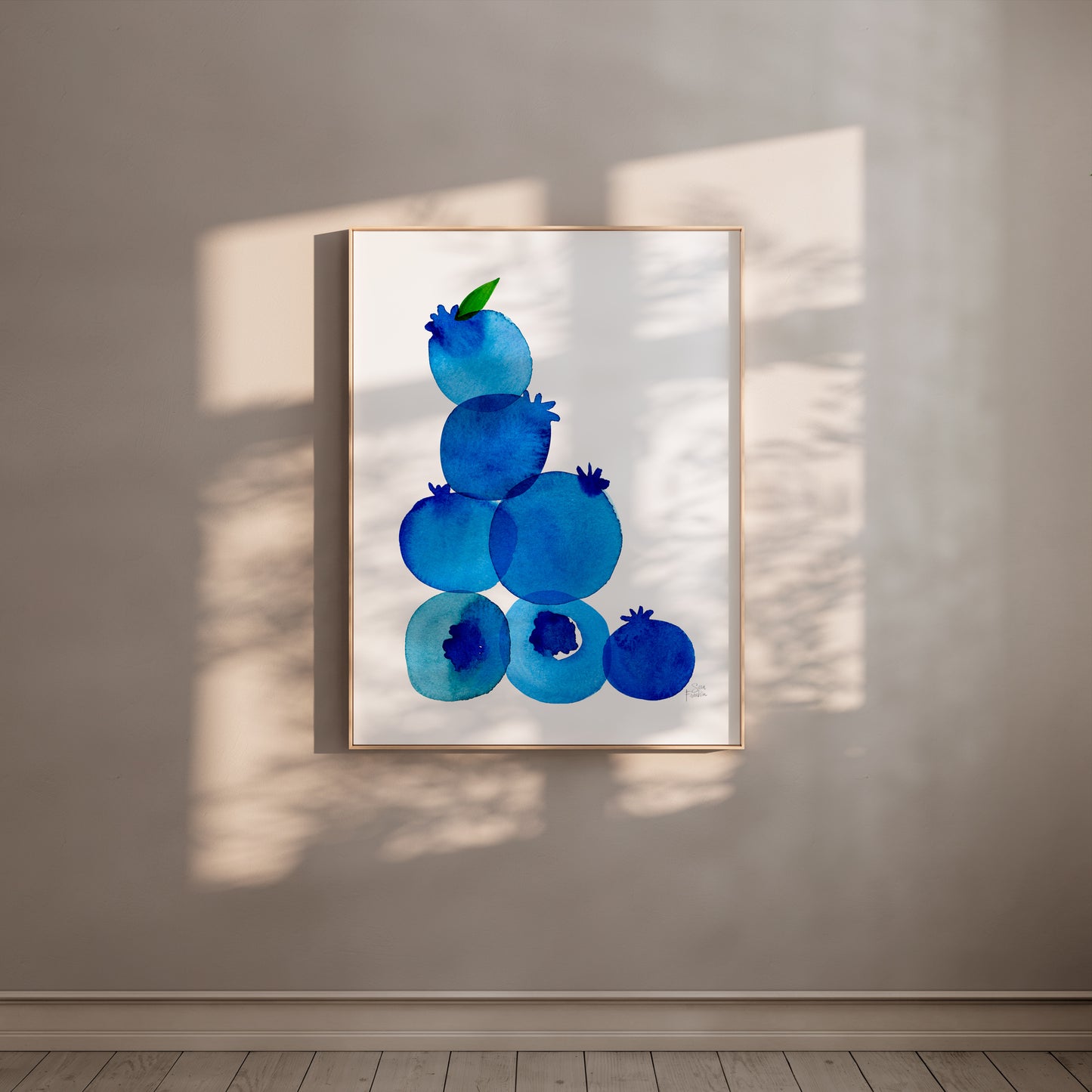 a framed artwork of blueberries hanging on a wall.