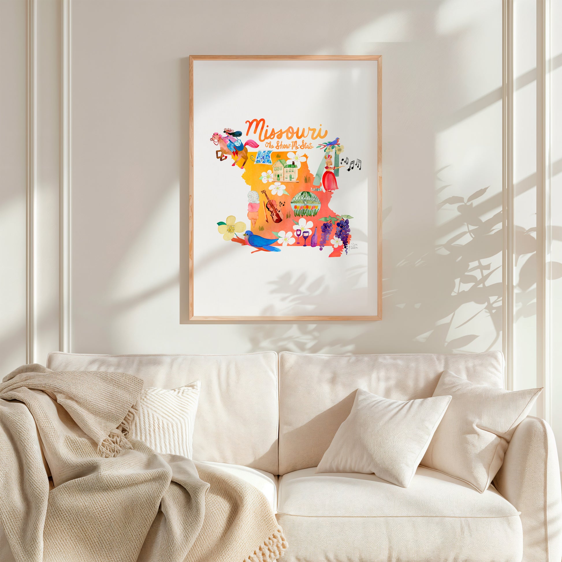 a living room with a white couch and a framed picture