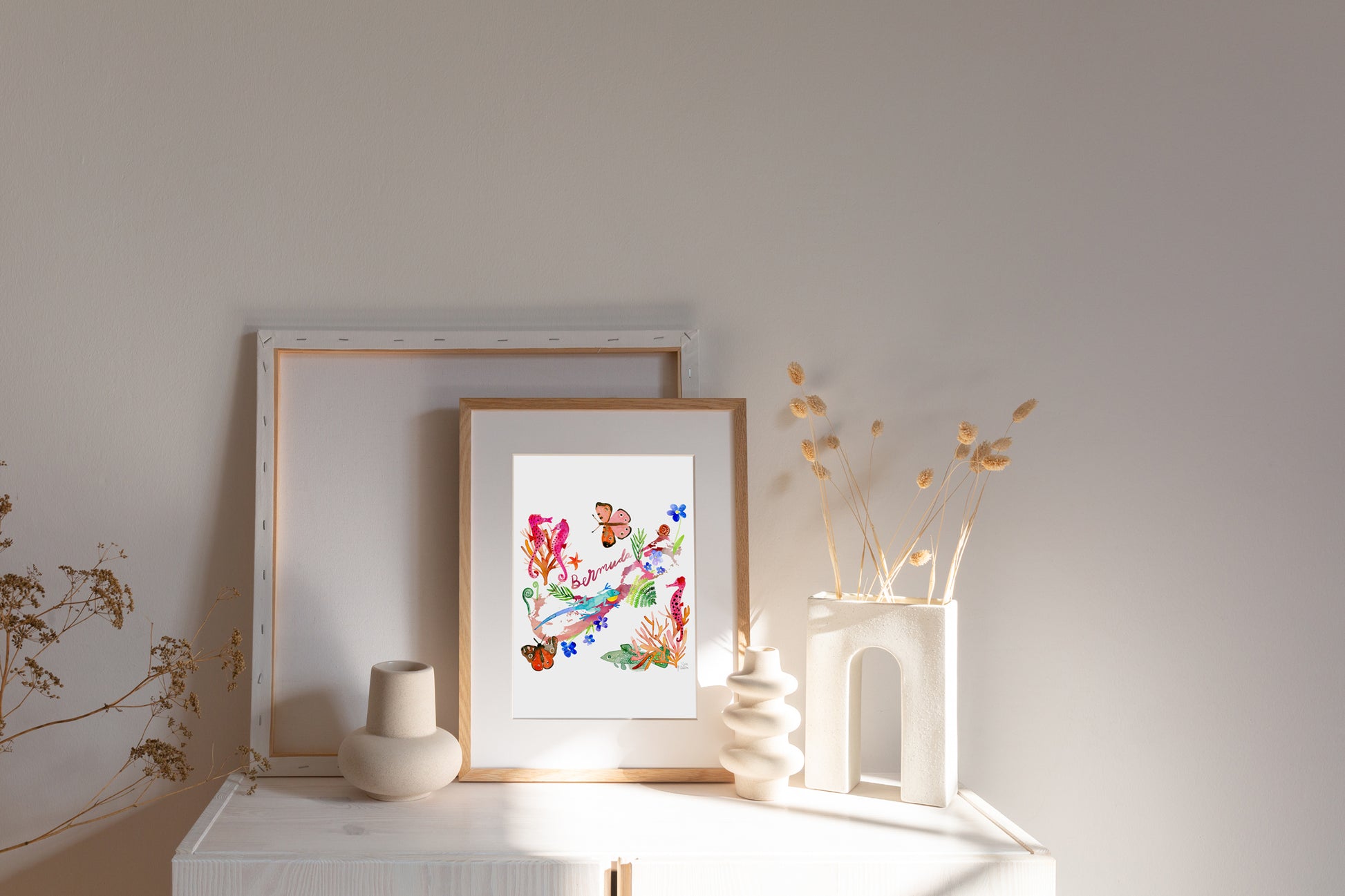 a white shelf with a picture and vases on it